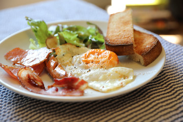 English breakfast fried egg bacon sausage bread and salad