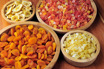 Dried and candied fruits in wooden bowls