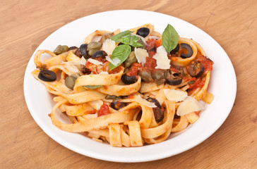 Linguine pasta with fresh tomato puttanesca sauce, cheese and basil