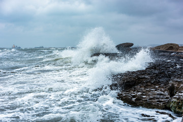 Splash of huge waves on a rocky shore