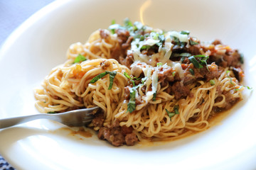 spaghetti Bolognese with minced beef and tomato sauce garnished with parmesan cheese and basil , Italian food