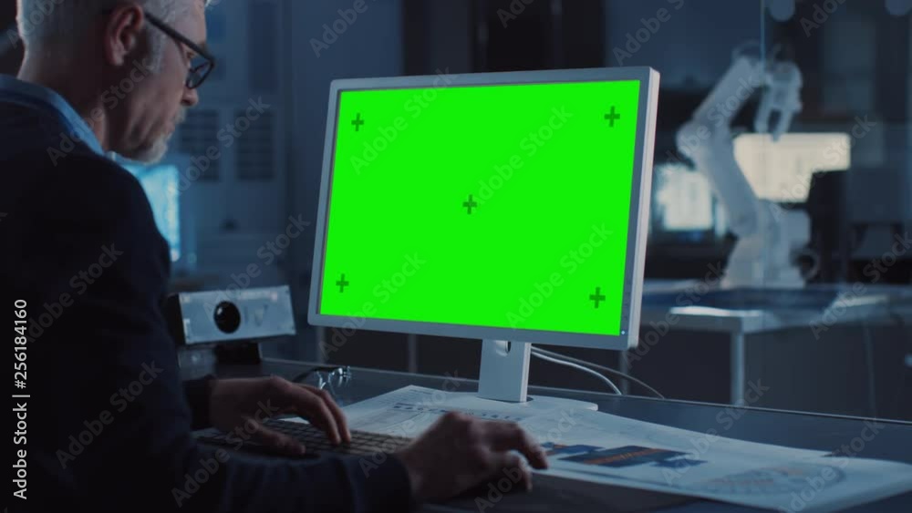 Poster Professional Heavy Industry Engineer Works on Green Mock-up Screen Computer. Engineering Bureau and Industrial Design Agency with Various Robotic, Architectural and Machinery Components
