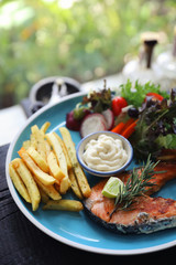Roasted salmon steak , baked salmon with salad fresh vegetable pm wooden table