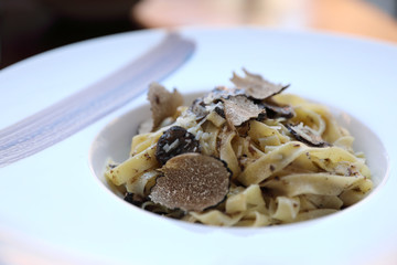 pasta with black truffles on wood background , Italian food