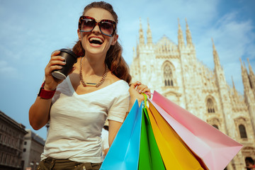 happy young woman with colorful shopping bags and coffee cup