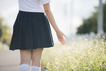 Portrait of asian japanese school girl costume hand walking with small white flower