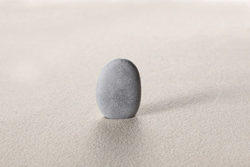 Fototapeta na wymiar zen stone concept: grey stoneson the sand with copy space for your text