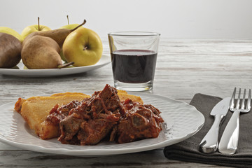 piatto con polenta e carne al sugo di pomodoro fronte