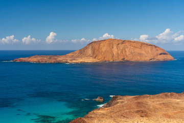 Naklejka premium Isla de Montana Clara island as seen from the top of Bermeja volcanic mountain on La Graciosa Island in Lanzarote, Spain. Atlantic Ocean seascape on a warm sunny day under a clear blue sky.