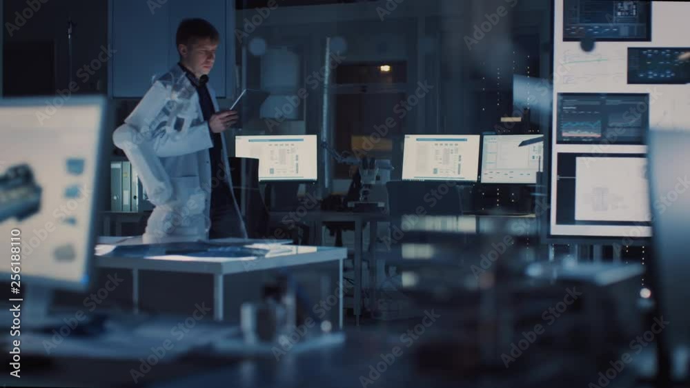 Leinwandbilder professional heavy industry robotics engineer wearing white coat holding tablet computer walks throu