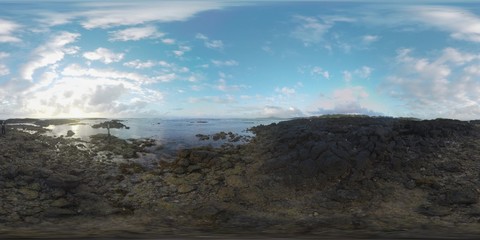 360 VR video. Scene of ocean coast with rocks and shallow water and a man controlling landing copter. Mauritius landscape at sunset
