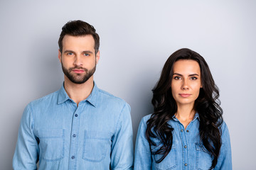 Close up portrait of two attractive fellows colleagues thinking about work problems questions listening attentively isolated in blue denim shirts over argent background