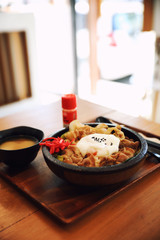 Japanese food Gyudon Japanese beef on rice bowl topped with egg on wooden table