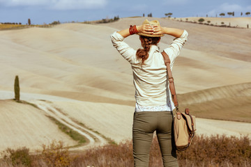 tourist woman on summer Tuscany trail looking into distance