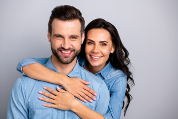 Portrait of attractive cute beautiful spouses gentle in comfort cozy cuddles showing ideal family marriage bonding wearing blue denim outfit isolated on ashy-gray background