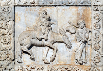 Flight ot Egypt, medieval relief on the facade of Basilica of San Zeno in Verona, Italy