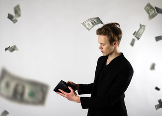 Young man and empty wallet. Currency, expense and income concept. Dollars