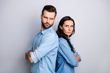 Scandals. Photo of sad irritated spouses standing back-to-back having outraged quarrels disagreement hatred isolated wearing blue denim clothes on argent background
