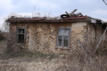 Destroyed house without a roof in an abandoned village.