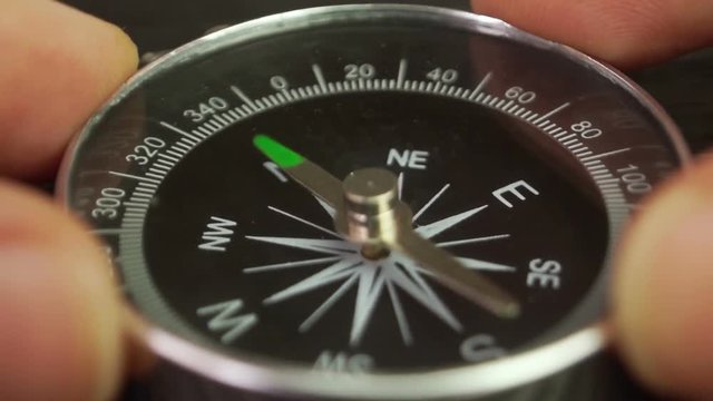 The person sets the compass needle to the north, close-up