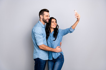 Close up photo couple she her he him his lady guy telephone smart phone hands arms make take selfies romantic date wear casual jeans denim shirts outfit clothes isolated light grey background