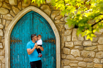 Father and his sun posing in front of old door