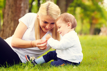 Beautiful blonde mother with her boy in park