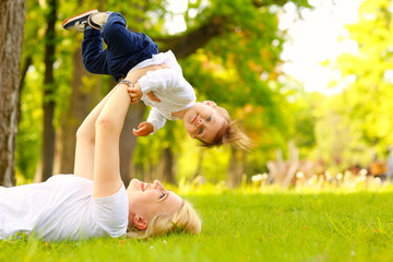 Beautiful blonde mother with her boy in park