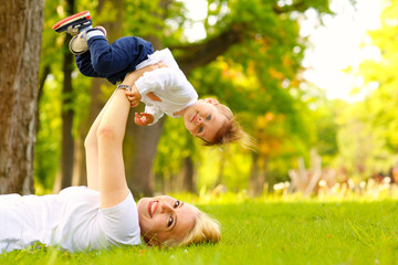 Beautiful blonde mother with her boy in park