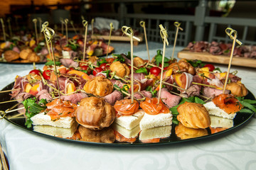 Delicious appetizers with meat and salmon on event. Catering service.