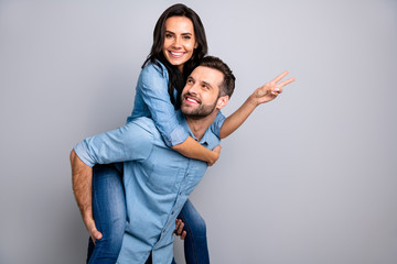 Close up side profile photo funky cheer she her he him his couple lady guy best friends piggyback ride buddies show v-sign wear casual jeans denim shirts outfit clothes isolated light grey background