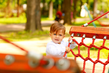 Portrait of beautiful smiling cute baby boy in park