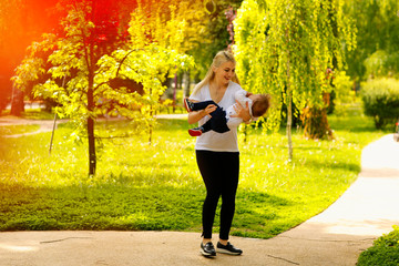 Beautiful mother and his son walking in park and having a good time together
