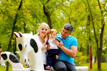 Happy joyful family father, mother and little son having fun outdoors