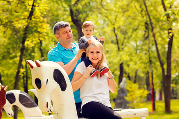 Happy joyful family father, mother and little son having fun outdoors