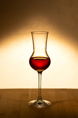 a glass of whiskey is on the table against a dark background