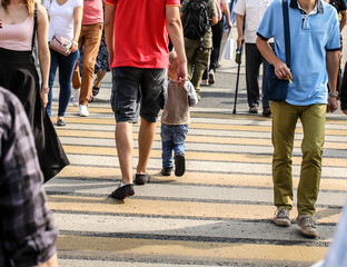 People in the city cross the road at a pedestrian crossing