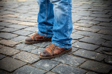 Fototapeta na wymiar Legs of men in jeans on the pavement