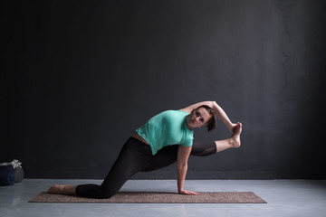 Fototapeta na wymiar Young woman wearing sportswear practicing yoga in studio,natural light.