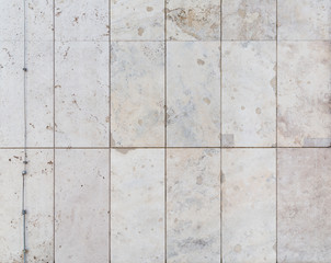 Full frame background of a modern and a bit broken wall or building exterior made of abstract stone slabs.