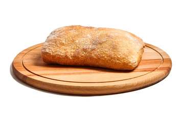 Bread ciabatta on a round wooden cutting board. Isolated on white background