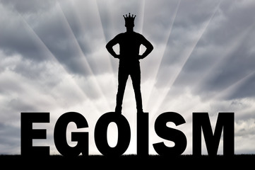 Silhouette of a man with a crown on his head is on the word ego
