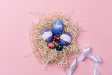 Easter eggs in nest with white ribbon on pink background. Easter texture
