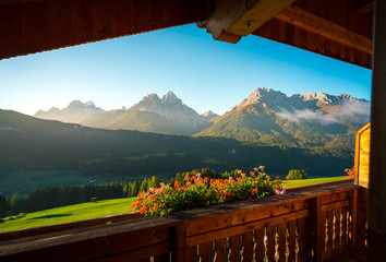splendid view of Dolomites mountains from a balcony of a wooden cottage. South Tyrol, Italy