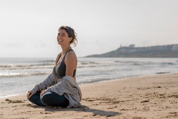 Fototapeta na wymiar chica meditando en la orilla del mar 