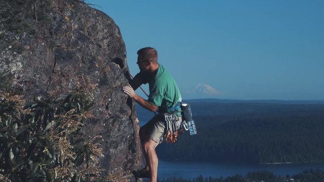 Man Rock Climbing with Mt Rainier Background