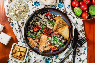 Cesar salad. Salad with marinated salmon, eggs, parmesan and tomatoes. Served with white wine. top view.