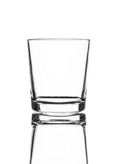 A single empty old fashioned glass isolated on a white background with reflection. High contrast black and white, black line lighting.