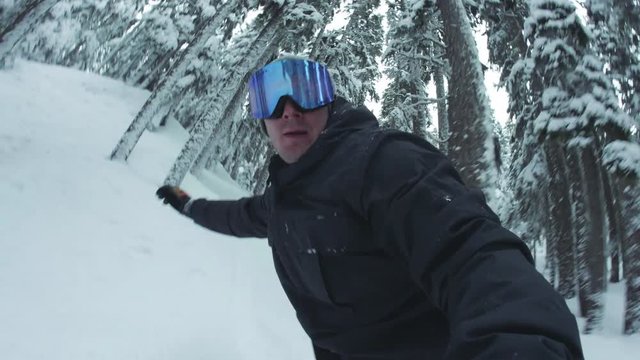 Man Snowboarding Hand Holding DSLR Camera in Trees