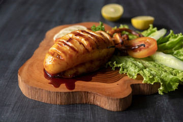 Fried squid on a wooden board with vegetables